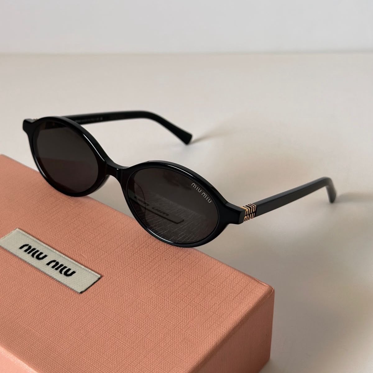 Lunettes de Soleil Miu Miu – Silhouette Ovale Chic (Disponible en Noir et Écaille)